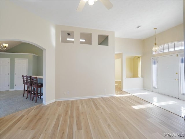 entrance foyer featuring ceiling fan with notable chandelier and light hardwood / wood-style floors