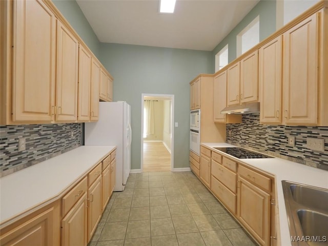 kitchen with white appliances, sink, light tile patterned floors, light brown cabinetry, and tasteful backsplash