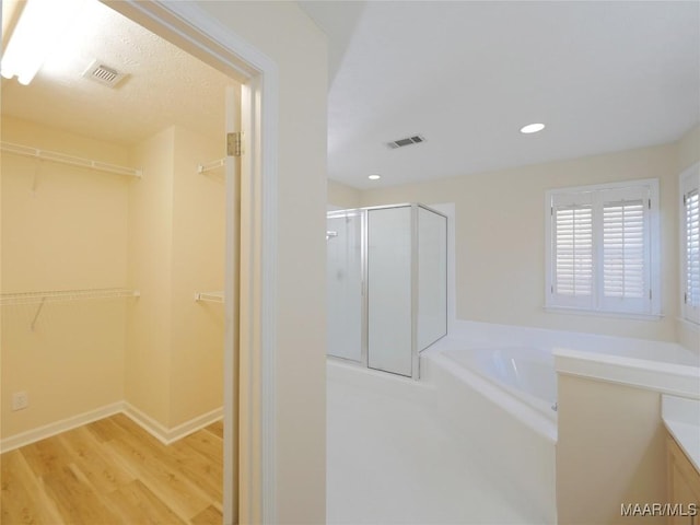 bathroom with hardwood / wood-style floors and separate shower and tub