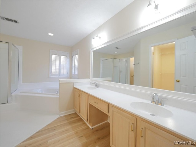 bathroom with vanity, wood-type flooring, and independent shower and bath