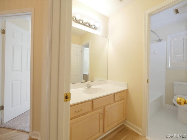 bathroom with hardwood / wood-style floors, vanity, and toilet