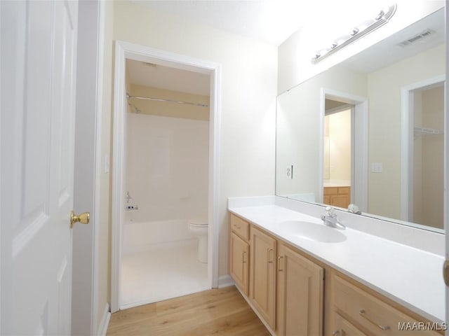 bathroom with hardwood / wood-style flooring, vanity, and toilet