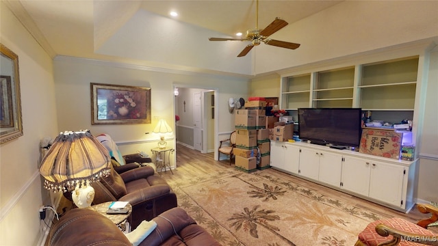 living room featuring ceiling fan, a raised ceiling, light hardwood / wood-style floors, lofted ceiling, and ornamental molding