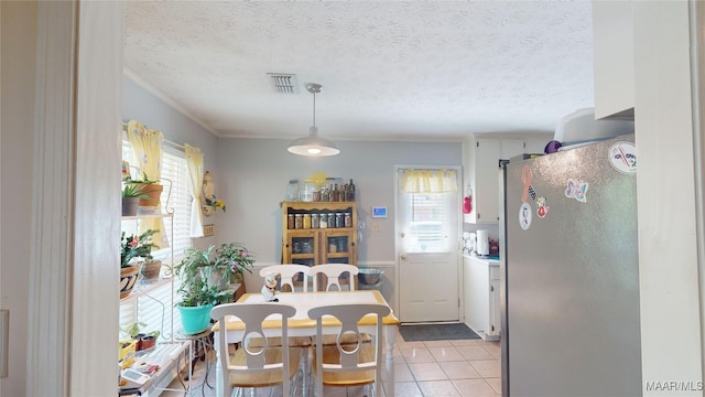 dining room featuring light tile patterned floors and a textured ceiling