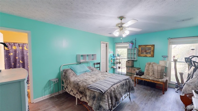 bedroom featuring dark hardwood / wood-style flooring, a textured ceiling, and ceiling fan