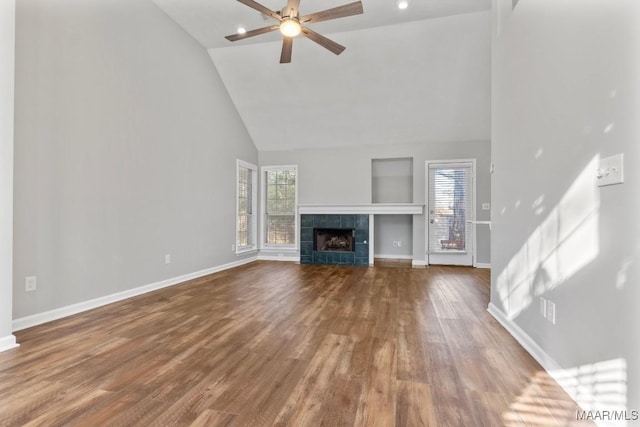 unfurnished living room featuring ceiling fan, a fireplace, high vaulted ceiling, and wood-type flooring