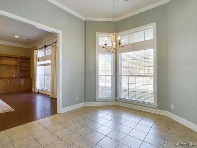 unfurnished room with light tile patterned floors, ornamental molding, and an inviting chandelier