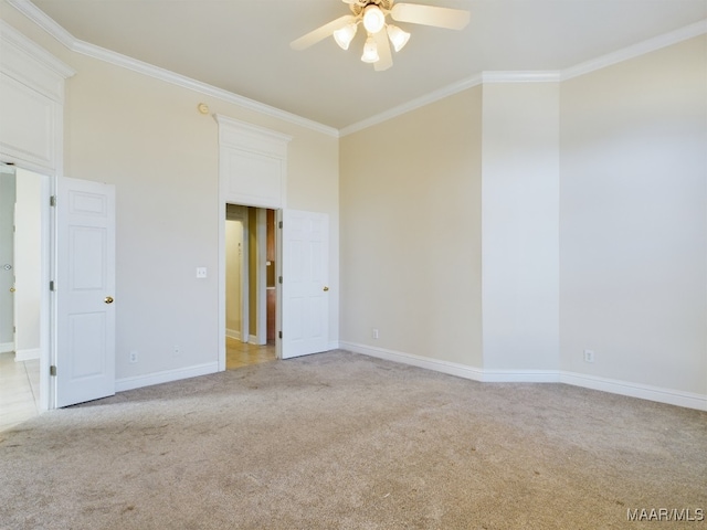 empty room featuring light colored carpet, ceiling fan, and crown molding