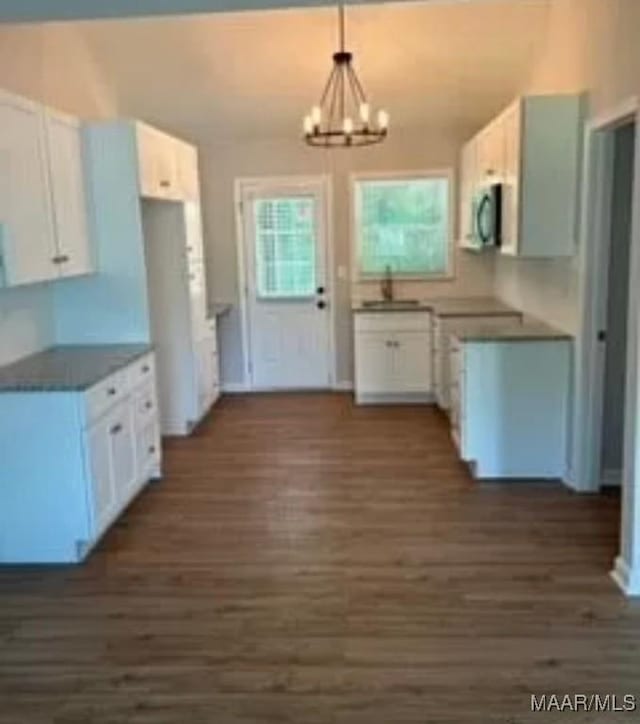 kitchen with white cabinets, pendant lighting, and an inviting chandelier