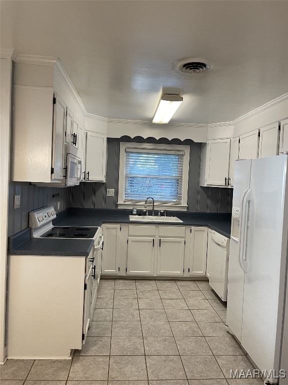 kitchen featuring tasteful backsplash, white appliances, sink, light tile patterned floors, and white cabinetry