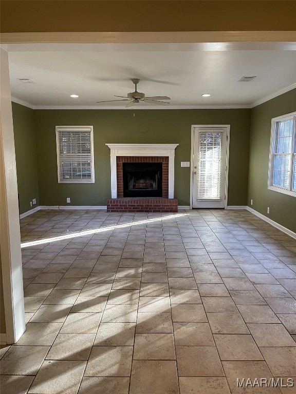 unfurnished living room with ceiling fan, light tile patterned flooring, ornamental molding, and a brick fireplace