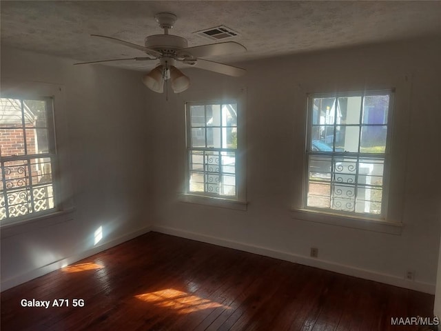 spare room with ceiling fan, hardwood / wood-style floors, a healthy amount of sunlight, and a textured ceiling