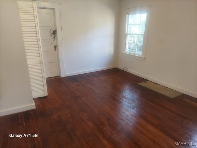 unfurnished room with dark hardwood / wood-style flooring