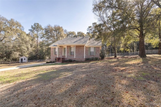 ranch-style house featuring an outbuilding and a front lawn