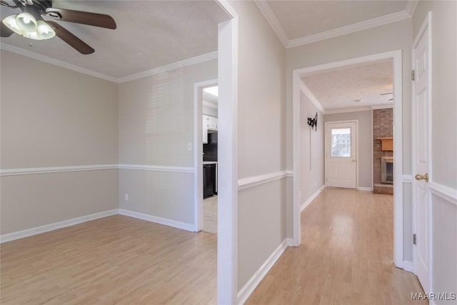 hall featuring a textured ceiling, light hardwood / wood-style flooring, and ornamental molding