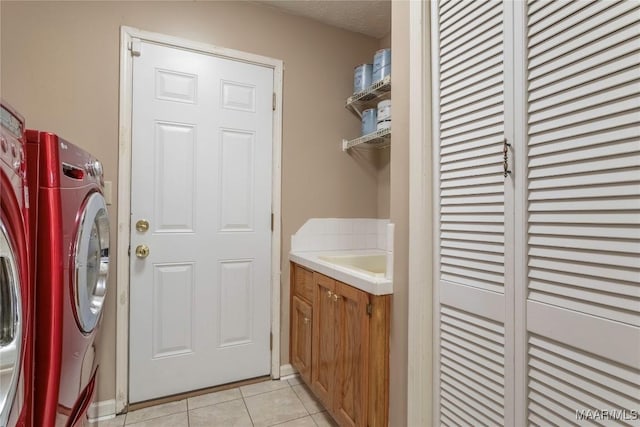 laundry room with washing machine and clothes dryer, sink, and light tile patterned flooring