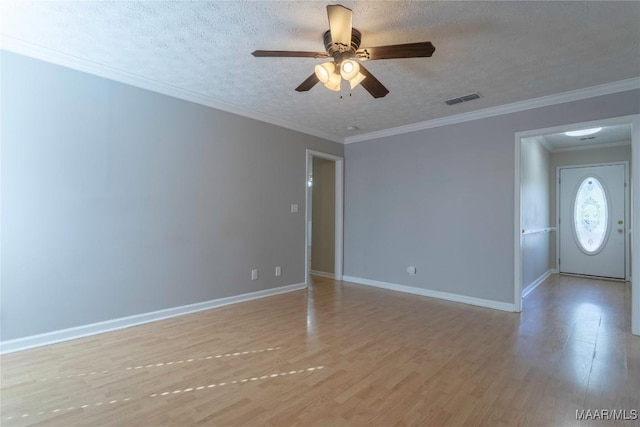 spare room featuring ceiling fan, light hardwood / wood-style flooring, a textured ceiling, and ornamental molding