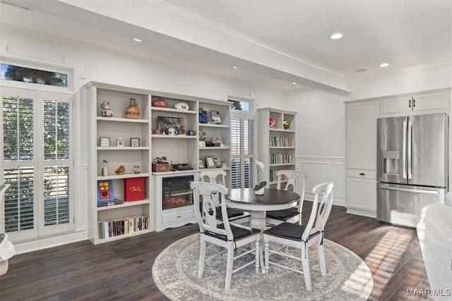 dining area with a wealth of natural light, crown molding, and dark hardwood / wood-style floors