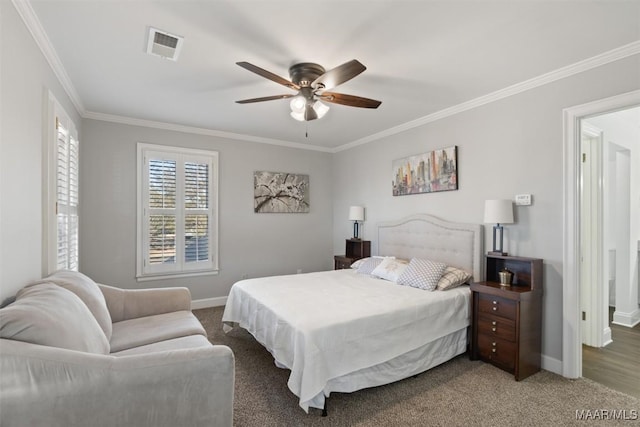 carpeted bedroom with ceiling fan and ornamental molding