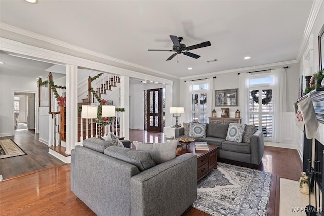 living room with wood-type flooring, ceiling fan, and ornamental molding