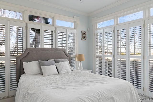 bedroom with ornamental molding and multiple windows