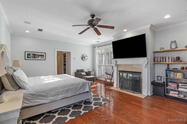 bedroom with dark hardwood / wood-style floors, ceiling fan, and crown molding