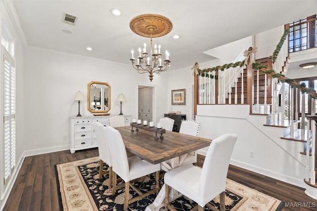 dining room featuring crown molding, dark wood-type flooring, and a notable chandelier