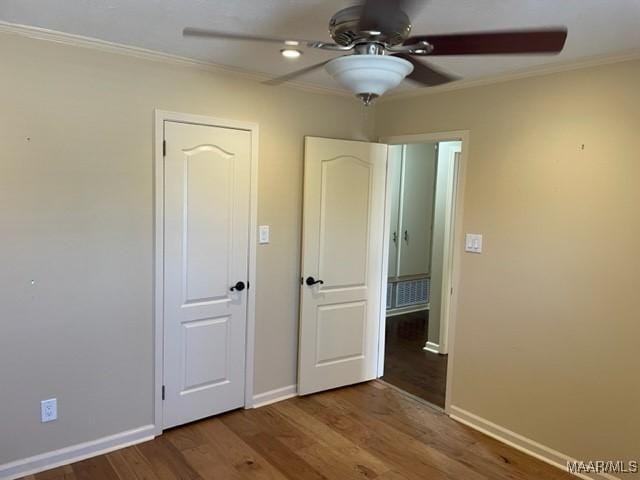 unfurnished bedroom with hardwood / wood-style flooring, ceiling fan, and ornamental molding