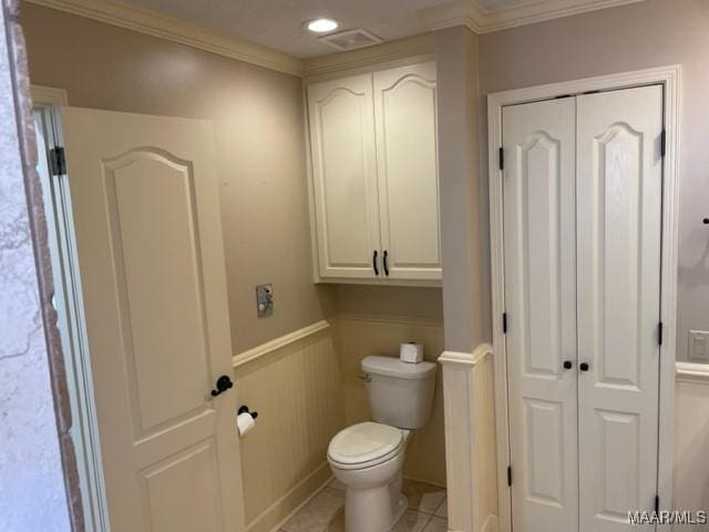 bathroom featuring toilet, tile patterned floors, and crown molding