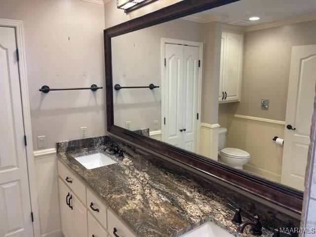 bathroom with vanity, toilet, and crown molding