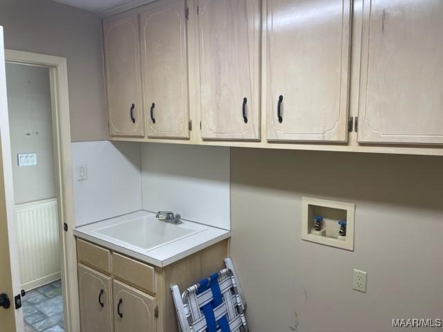 clothes washing area featuring hookup for a washing machine, sink, and cabinets