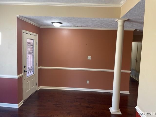 interior space featuring decorative columns, crown molding, a textured ceiling, and dark hardwood / wood-style floors