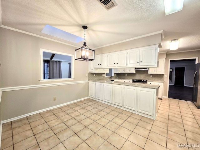 kitchen with white cabinetry, stainless steel range oven, decorative light fixtures, decorative backsplash, and black refrigerator