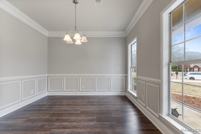 empty room with dark wood-type flooring, crown molding, and an inviting chandelier