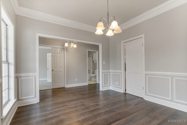 unfurnished dining area with crown molding, dark hardwood / wood-style flooring, and a chandelier