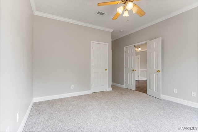 unfurnished bedroom featuring carpet, ceiling fan, and crown molding