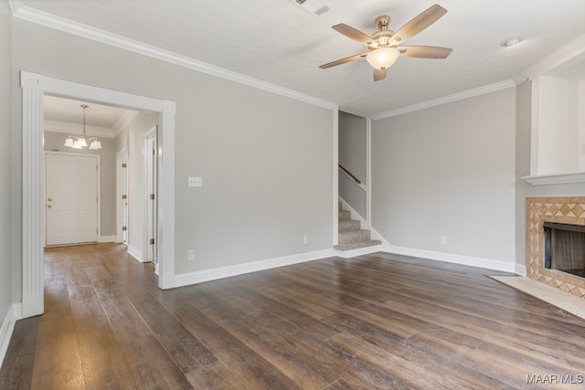 unfurnished living room featuring ceiling fan with notable chandelier, dark hardwood / wood-style floors, ornamental molding, and a tiled fireplace