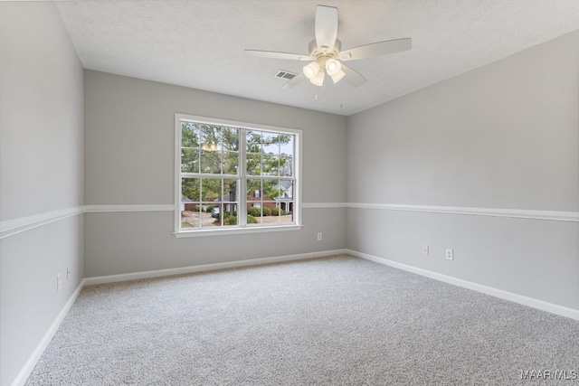 carpeted empty room with ceiling fan and a textured ceiling