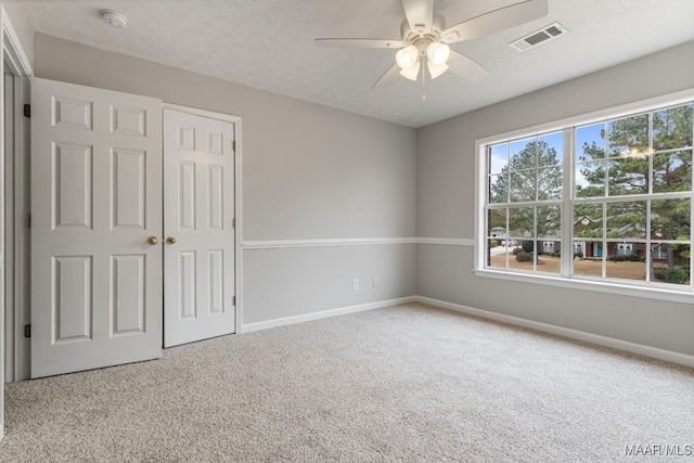 unfurnished bedroom featuring carpet, a closet, and ceiling fan