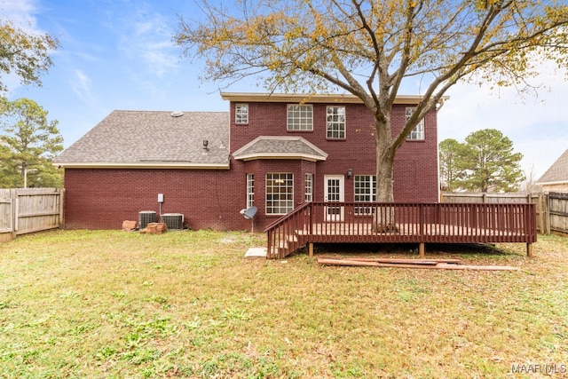 rear view of property featuring a wooden deck, a yard, and cooling unit