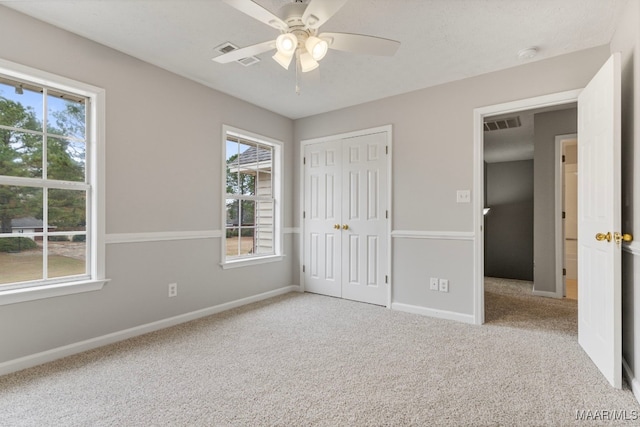 unfurnished bedroom with ceiling fan and light colored carpet