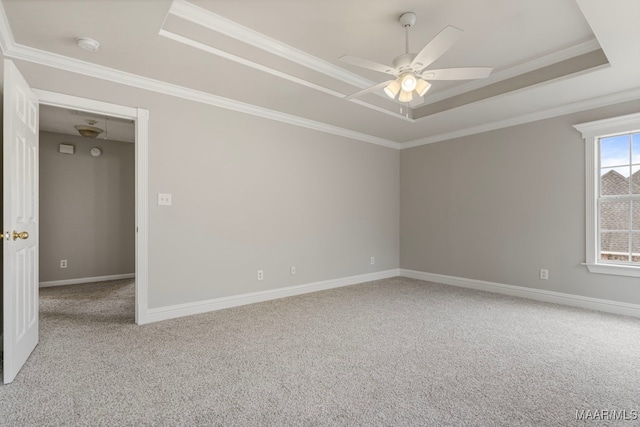 carpeted spare room with ceiling fan, crown molding, and a tray ceiling