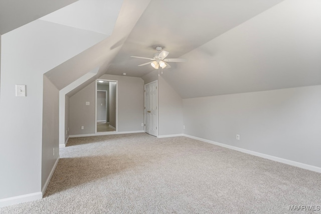 additional living space featuring light colored carpet, vaulted ceiling, and ceiling fan