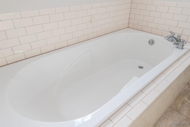 bathroom with a relaxing tiled tub