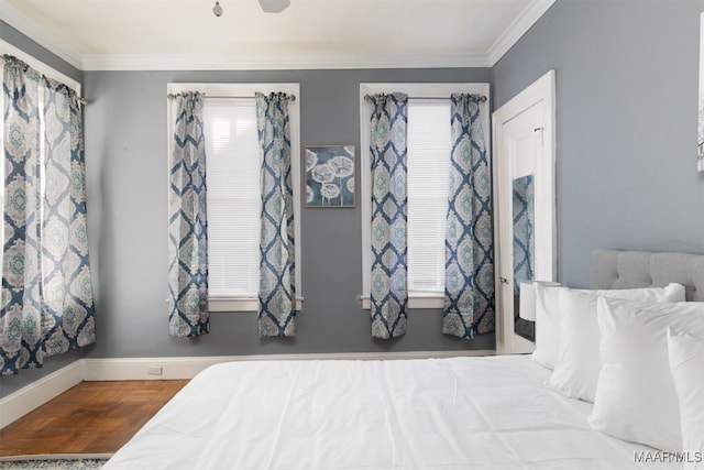 bedroom with hardwood / wood-style floors, multiple windows, and ornamental molding