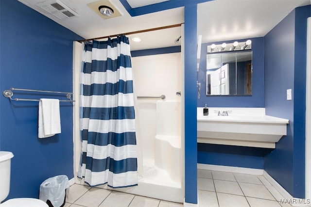 bathroom featuring tile patterned flooring, a shower with curtain, toilet, and vanity