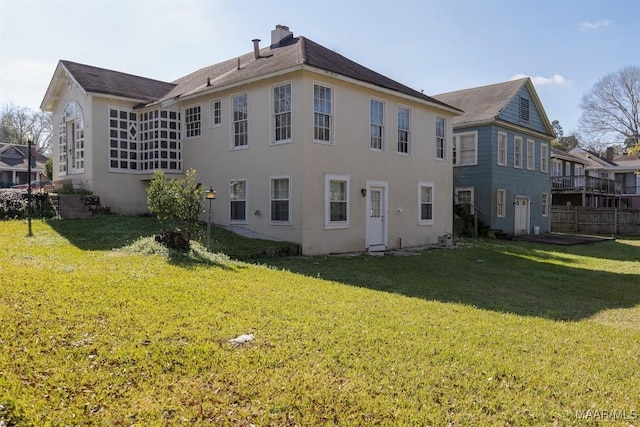 rear view of house featuring a yard