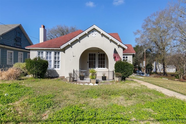 back of house featuring a lawn and a porch