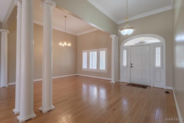 entryway featuring light wood-type flooring, decorative columns, an inviting chandelier, and ornamental molding