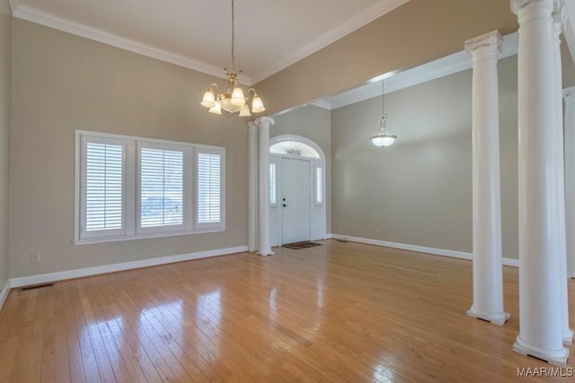 interior space with ornamental molding, light hardwood / wood-style floors, ornate columns, and a notable chandelier